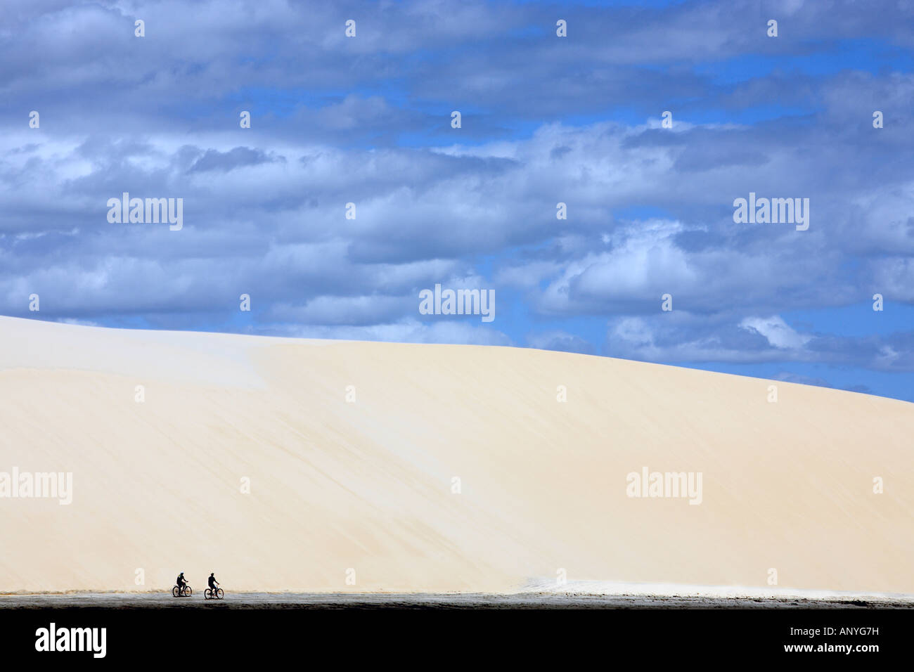 Tourist facendo bicicletta in corrispondenza del fondo della grande duna di sabbia sulla spiaggia del bellissimo villaggio di pescatori di Jericoacoara in stato di ceara brasile Foto Stock