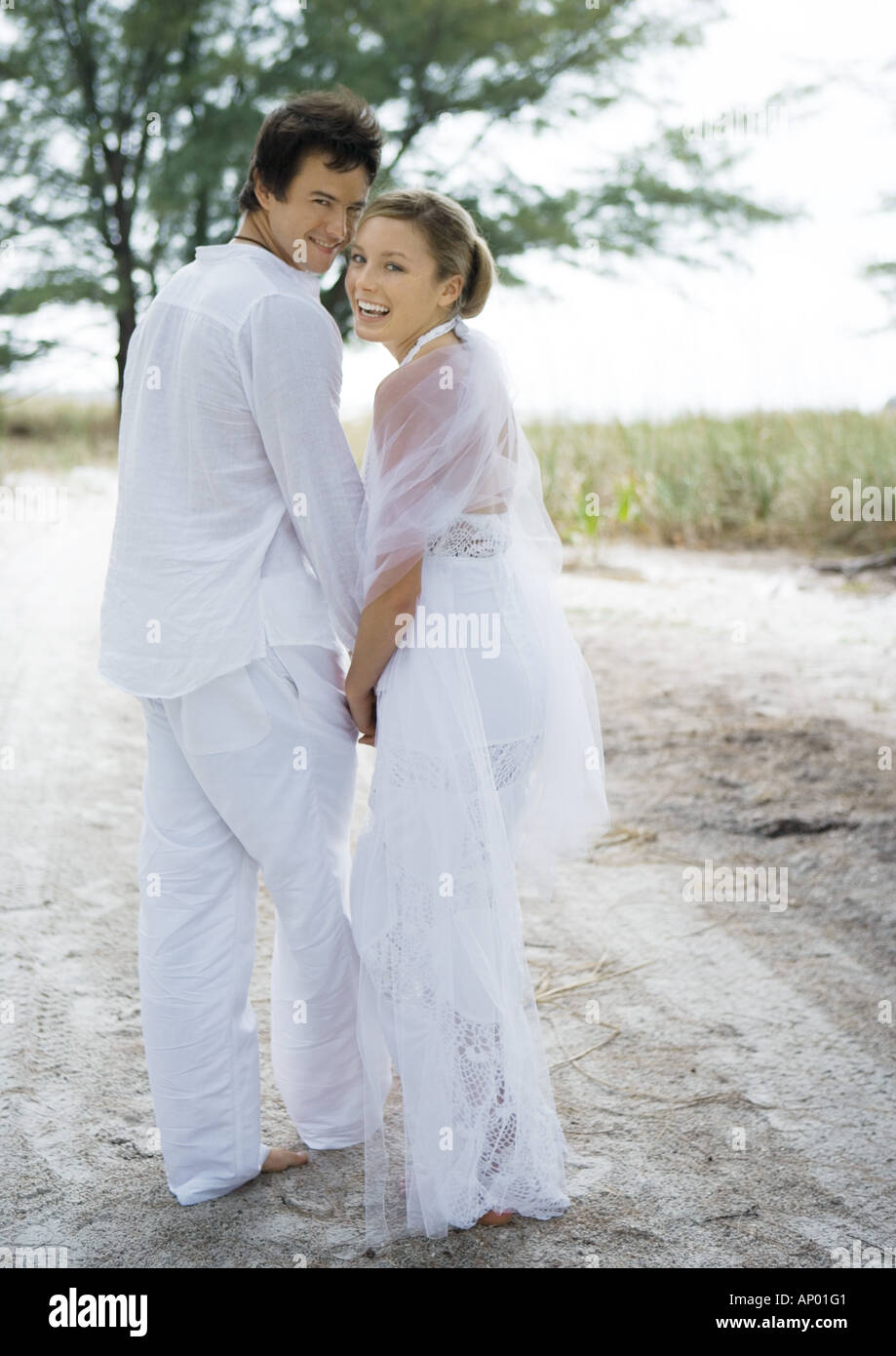 Sposa e lo sposo a camminare sulla sabbia Foto Stock