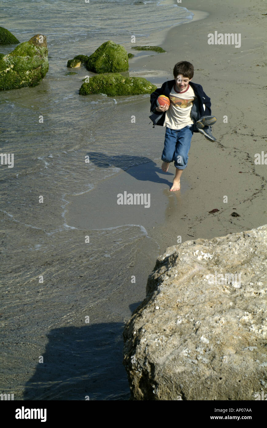 Francia Marsiglia La Spiaggia Prophete Giovane ragazzo in esecuzione su di una spiaggia di sabbia Foto Stock