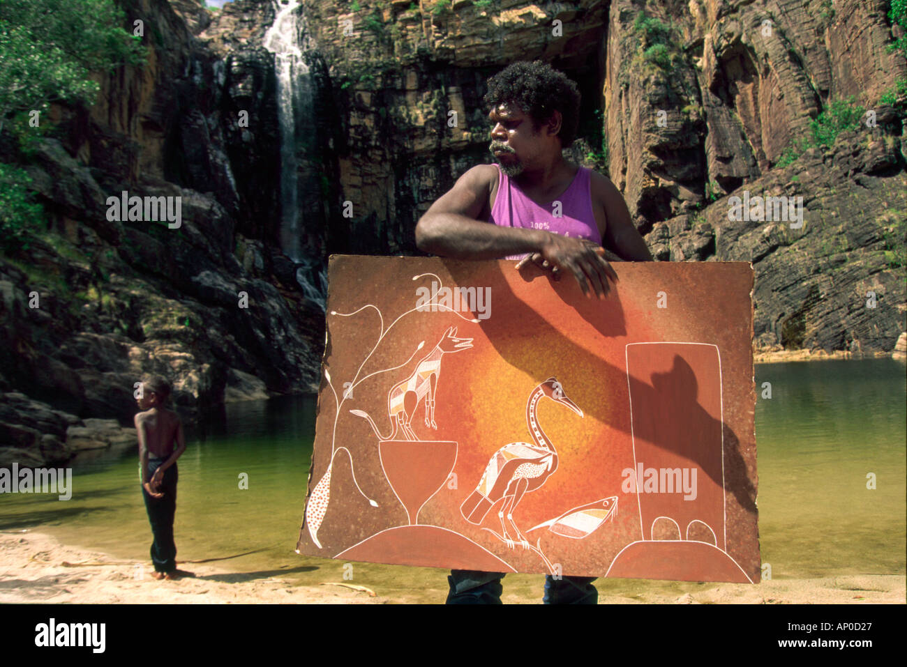 Artista aborigena Tony Bangalang la sua pittura del leggendario Adjumarllarl dingo a scared waterhole nella parte orientale di Arnhem Land Foto Stock