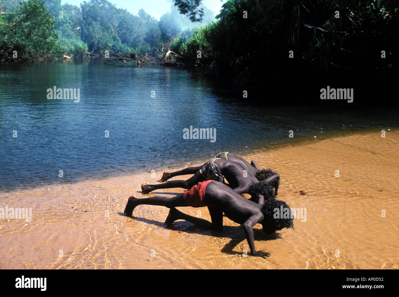 I bambini aborigeni di bere dal fiume Mann in remote central Arnhem Land Foto Stock
