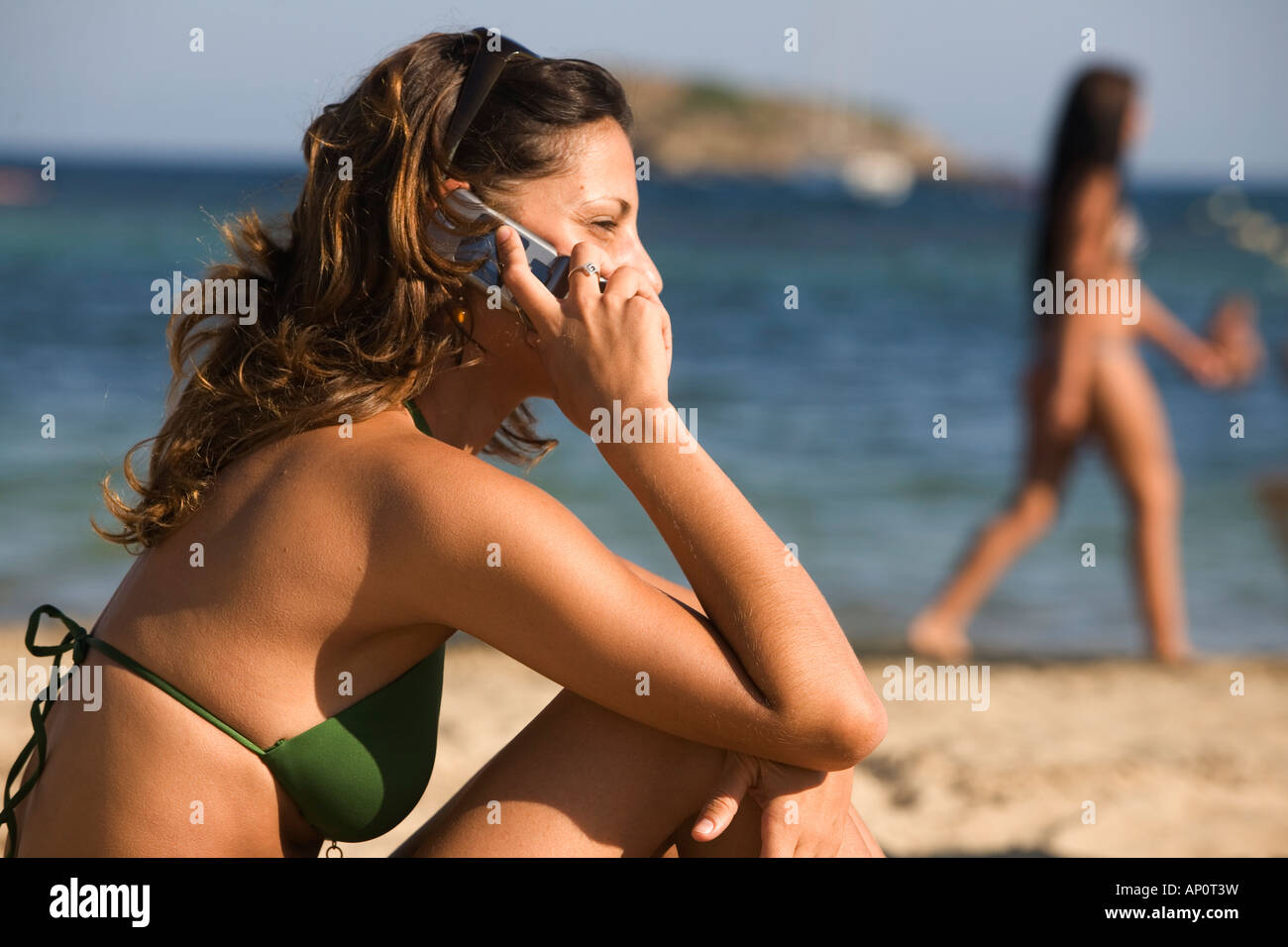 Femmina Telefono Mobile utente presso la spiaggia di Santa Eulalia, Ibiza / Eivissa, isole Baleari, Spagna, Europa UE Foto Stock