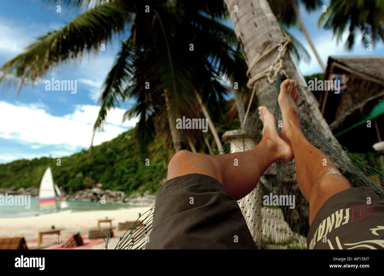 L'uomo rilassante in un hannock sulla spiaggia, Koh Phangan, Thailandia Foto Stock