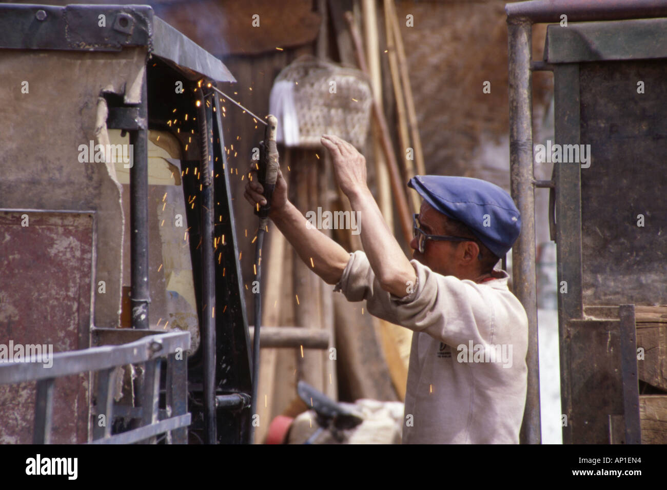 Uomo con saldatura insufficiente protezione degli occhi,scintille battenti,Lijiang,nella provincia dello Yunnan,Cina. Foto Stock