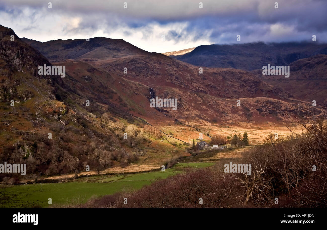 Un agriturismo è immerso nella luce del sole da un'interruzione nelle nubi nel Parco Nazionale di Snowdonia, il Galles del Nord Foto Stock