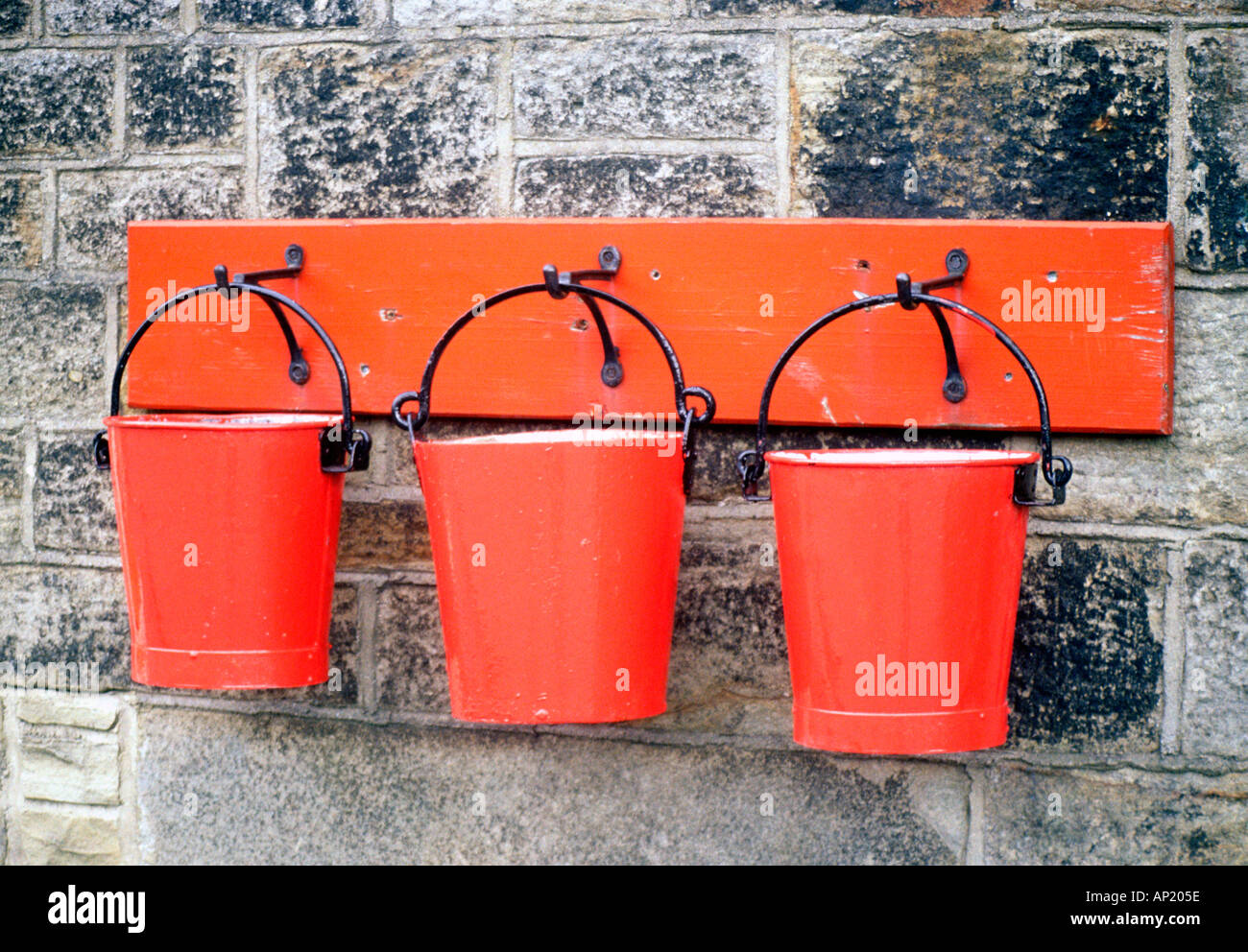 Le attrezzature antincendio 3 tre rossi secchi secchi muro di pietra estinguere estintore acqua di sabbia Foto Stock