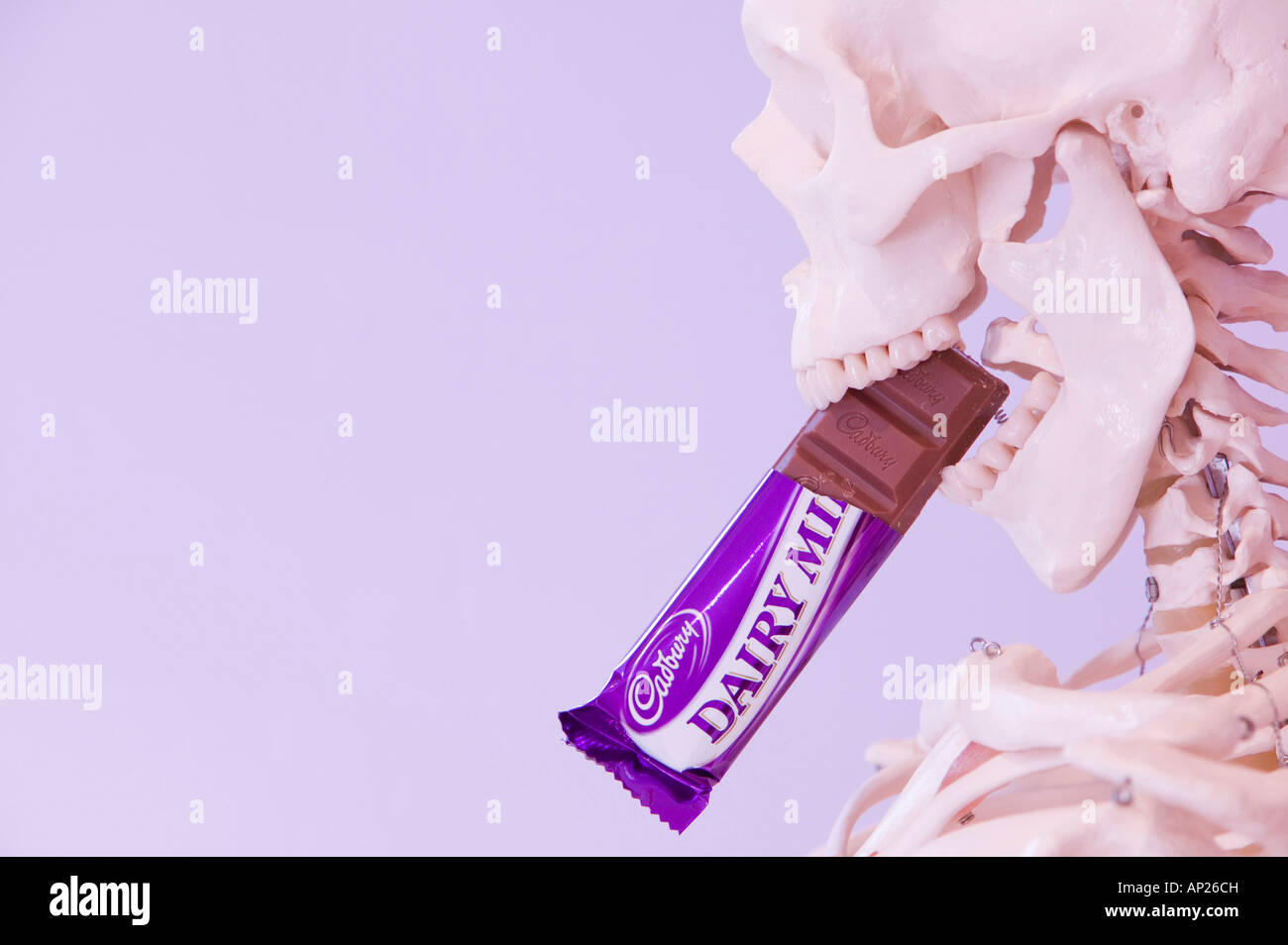 Uno scheletro umano a mangiare una barretta di cioccolato Foto Stock