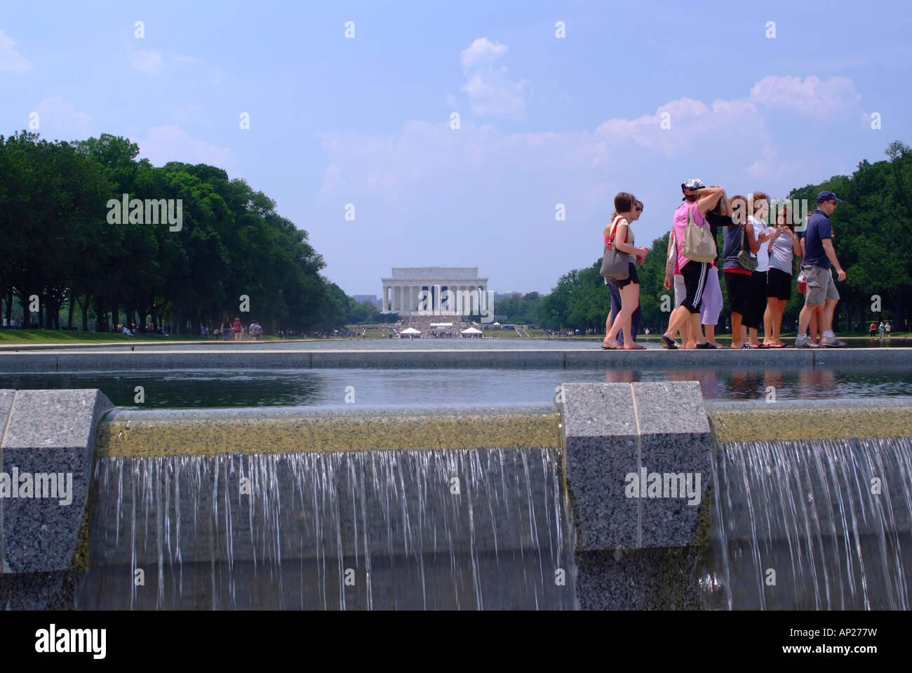 I turisti sul percorso dalla piscina riflettente dal Memoriale della Seconda Guerra Mondiale con il Lincoln Memorial National Mall di Washington DC USA Foto Stock