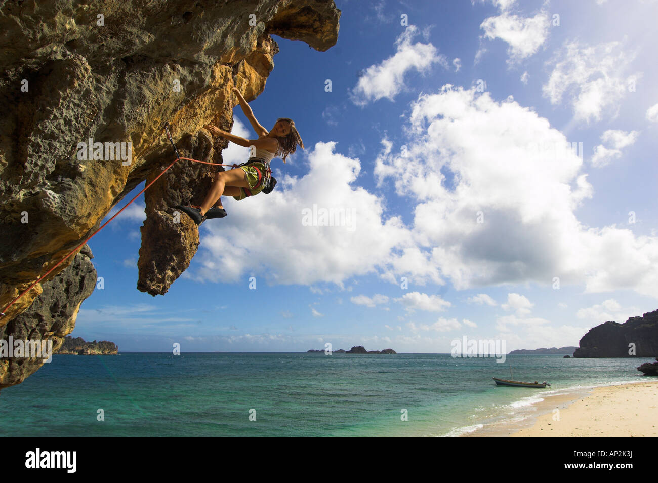 Una donna arrampicata sulle rocce vicino alla spiaggia, Andantsara, Madagascar, Africa Foto Stock