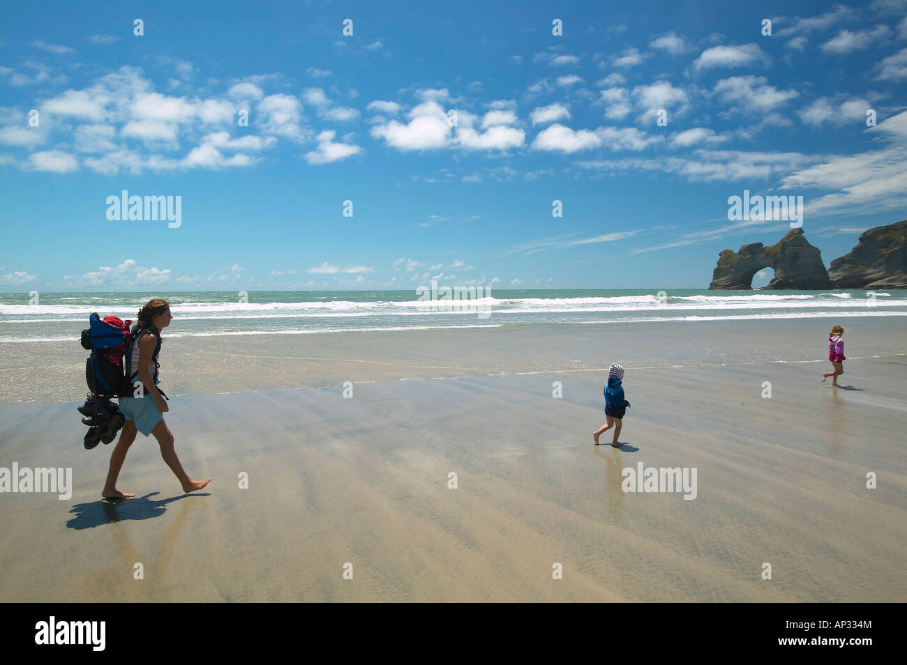 Famiglia escursioni su Wharariki Beach, bassa marea, vicino Puponga, costa nordoccidentale di South Island, in Nuova Zelanda Foto Stock