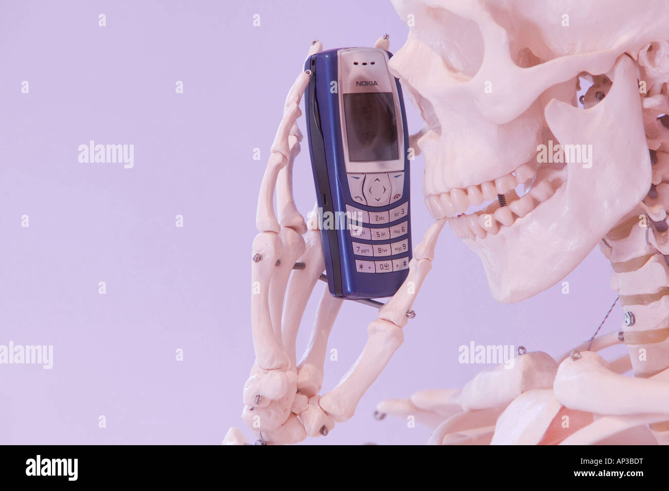 Uno scheletro umano a parlare su un telefono mobile Foto Stock