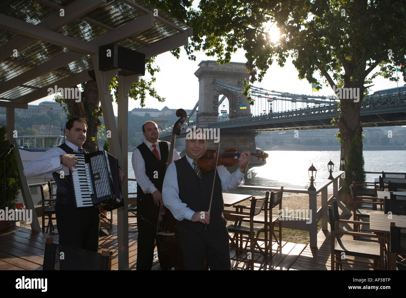 I musicisti a Outdoor Cafe e la catena ponte sul fiume Danubio, Pest, Budapest, Ungheria Foto Stock