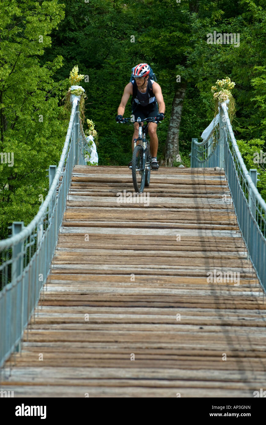 Mountainbiker sul ponte di sospensione, Slovenia Foto Stock