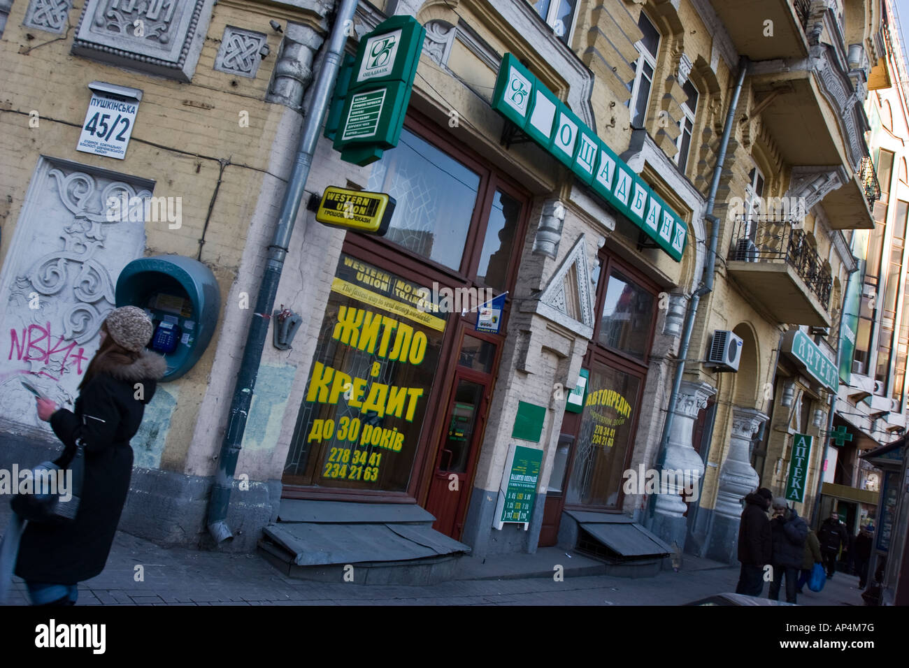Un pedone passa un ramo del 'National Savings Bank di Ucraina,' (Oshadbank) a Kiev, Ucraina Foto Stock
