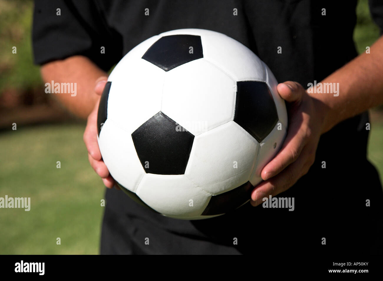 Uomo con pallone da calcio nelle sue mani come egli sta per dare via o  prendere un calcio Foto stock - Alamy