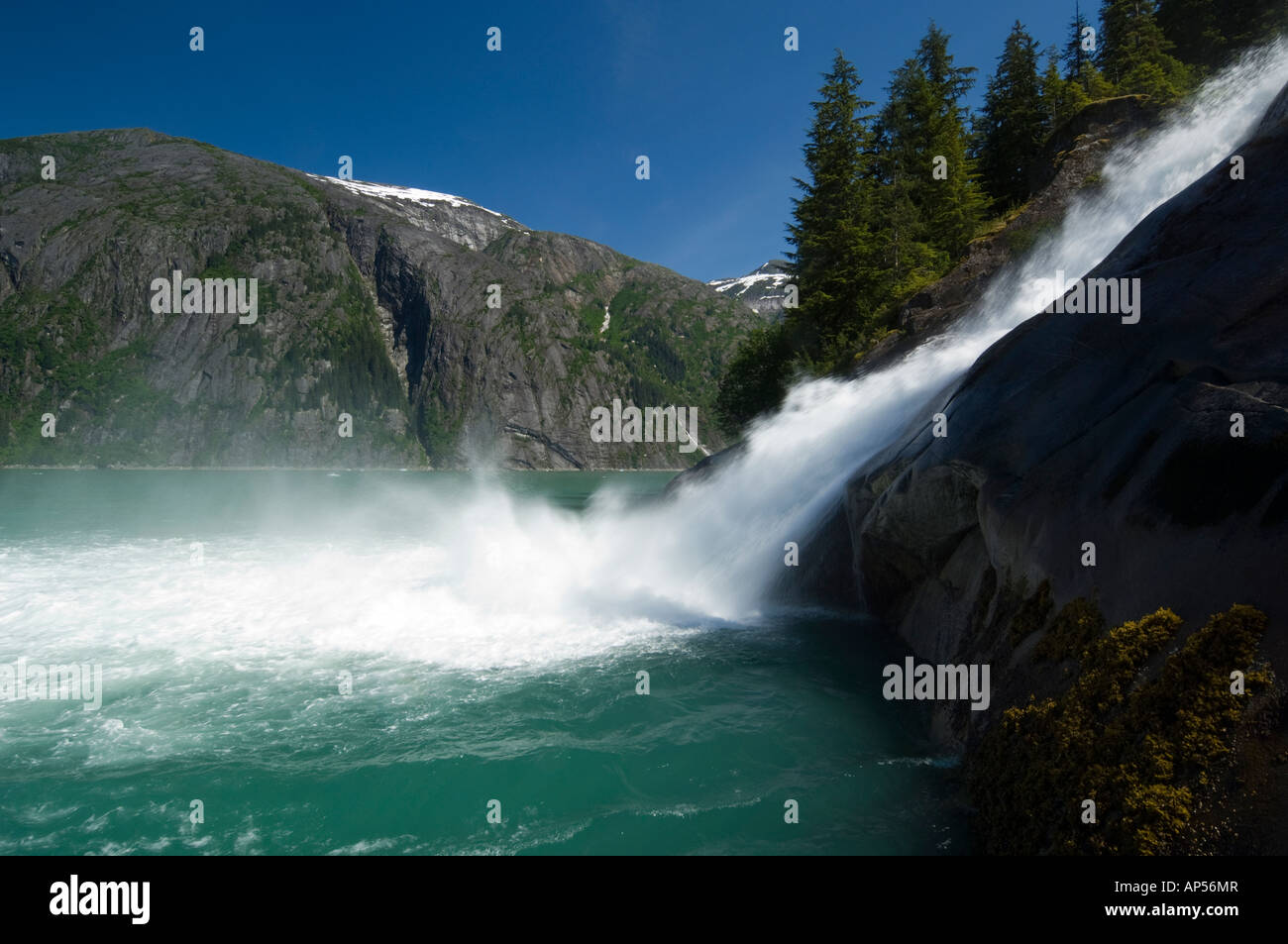 Cascata precipita sulle rocce in aqua acque di Tracy Arm Fjord, Alaska USA Foto Stock