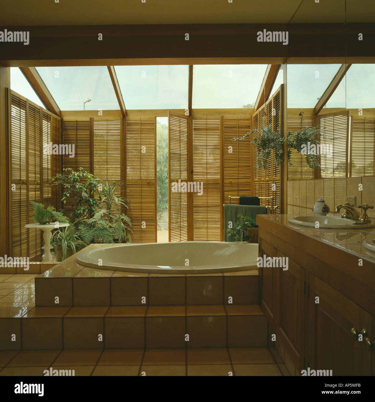 Circolare sollevata in bagno moderno bagno interno con persiane in stile piantagione su finestre alte Foto Stock