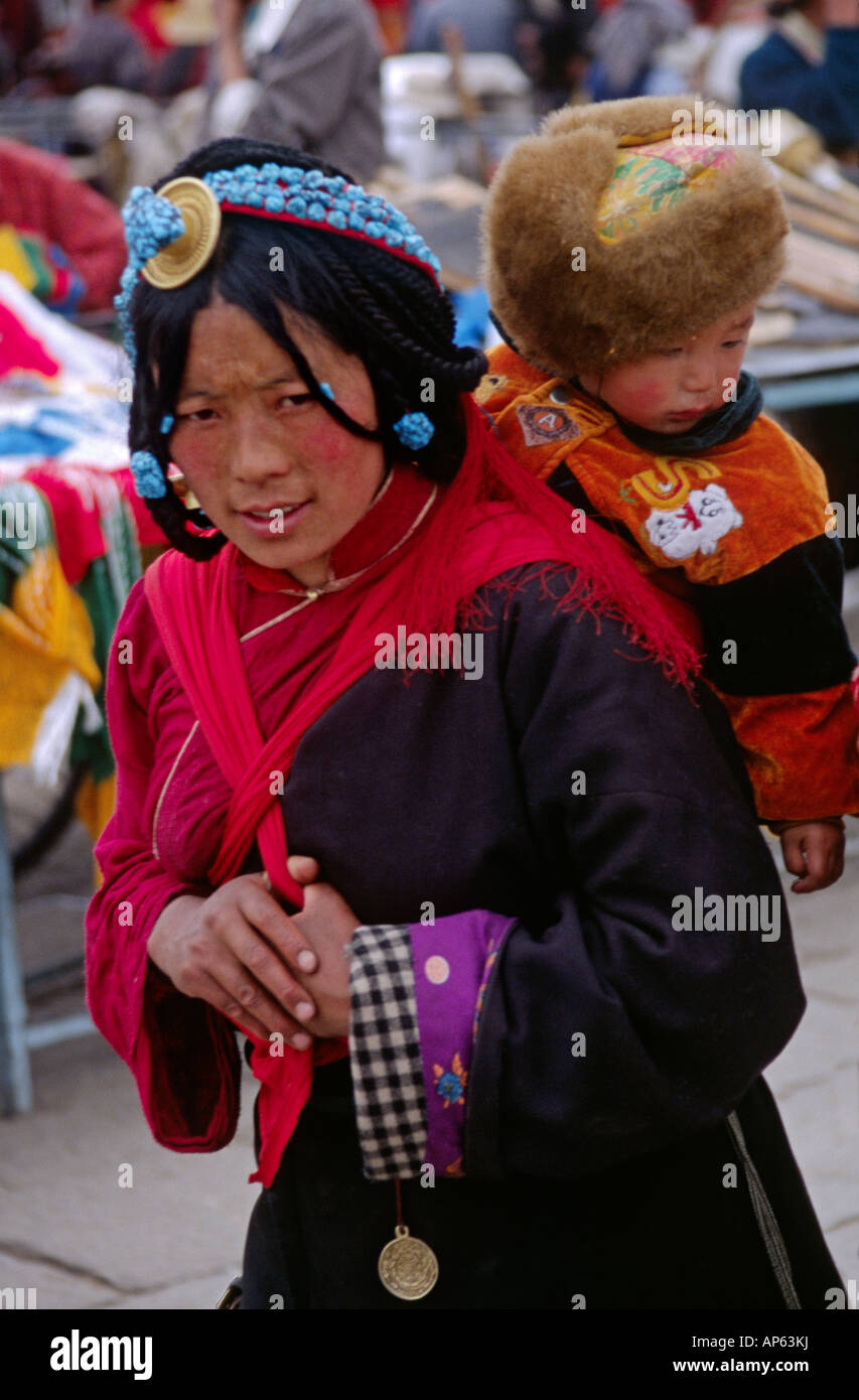 Il Tibetano madre bambino circumambulate il tempio del Jokhang lungo il BARKOR Bazaar Tibetana di Lhasa TIBET Foto Stock