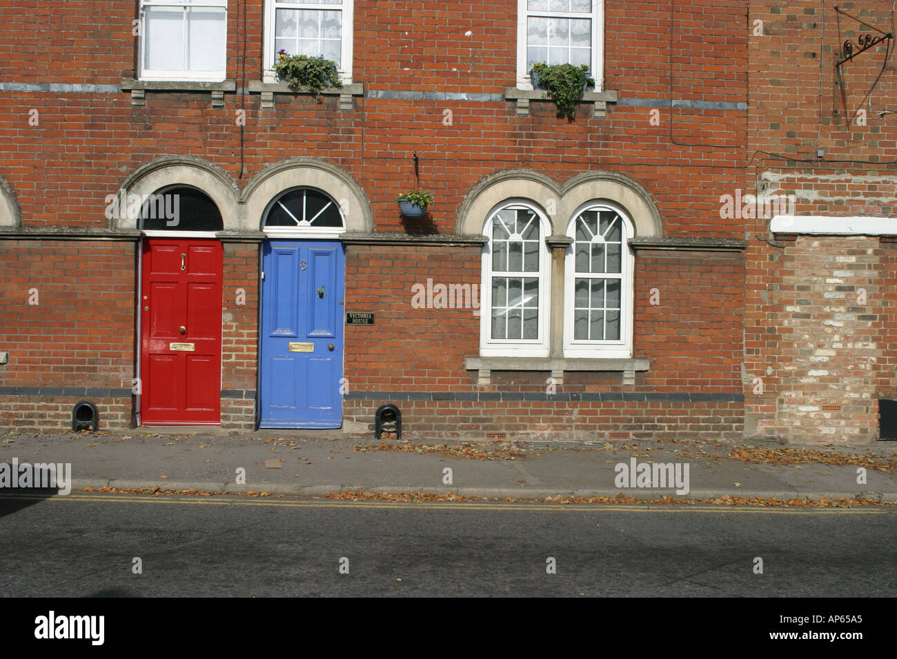 Due dipinto luminosamente porte anteriori in un rosso mattone strada terrazzati in Highworth Wiltshire Foto Stock Due dipinto luminosamente porte anteriori in un rosso mattone strada terrazzati in Highworth Wiltshire Foto Stock