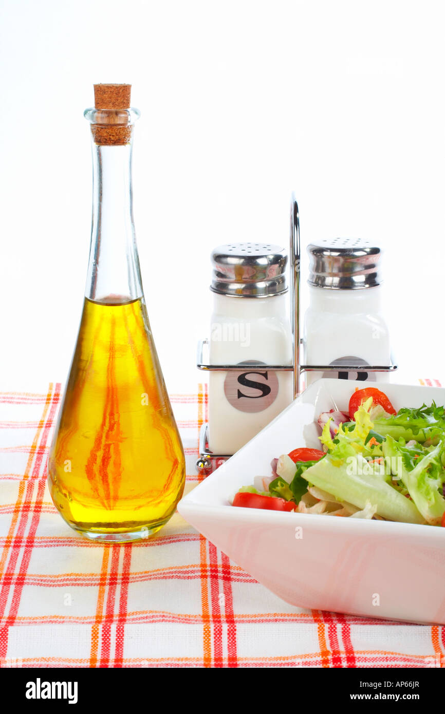 Olio di oliva Bottiglia insalata verde nella ciotola sale e pepe Foto Stock