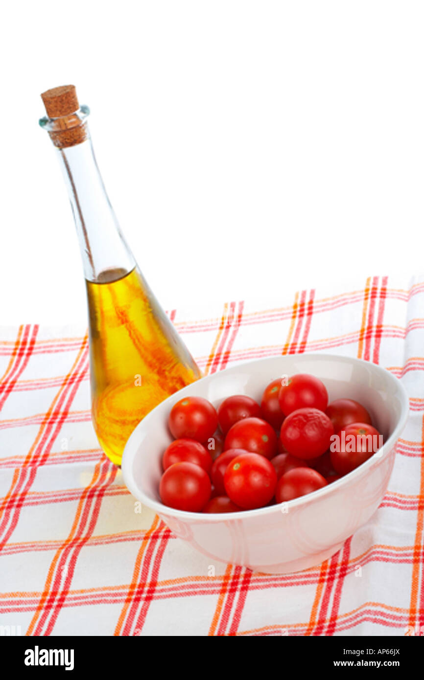 Olio di oliva Bottiglia di Rosso e i pomodori ciliegia nel recipiente Foto Stock