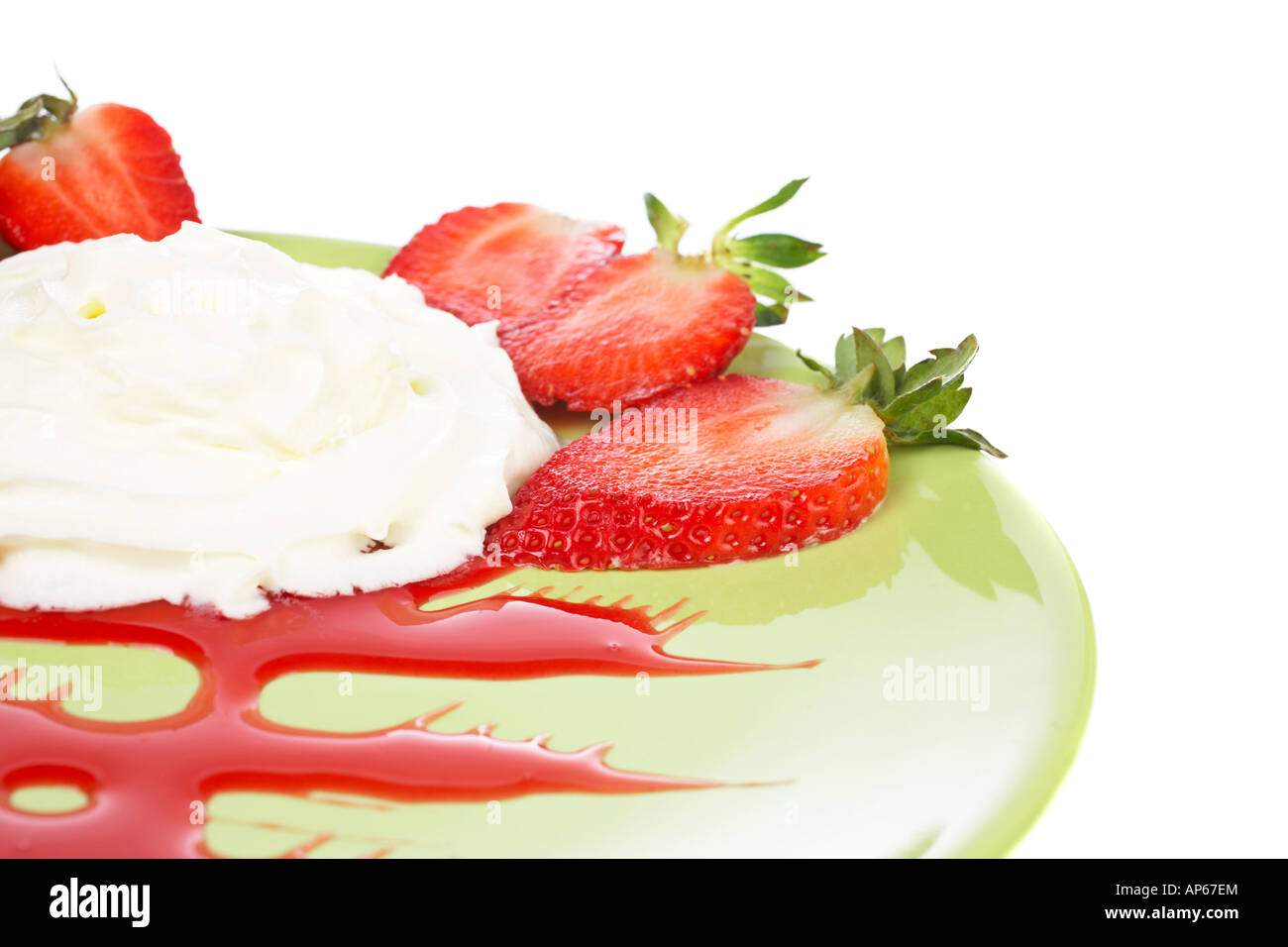 Il dessert di fragole con panna sul piatto verde DOF poco profondo Foto Stock