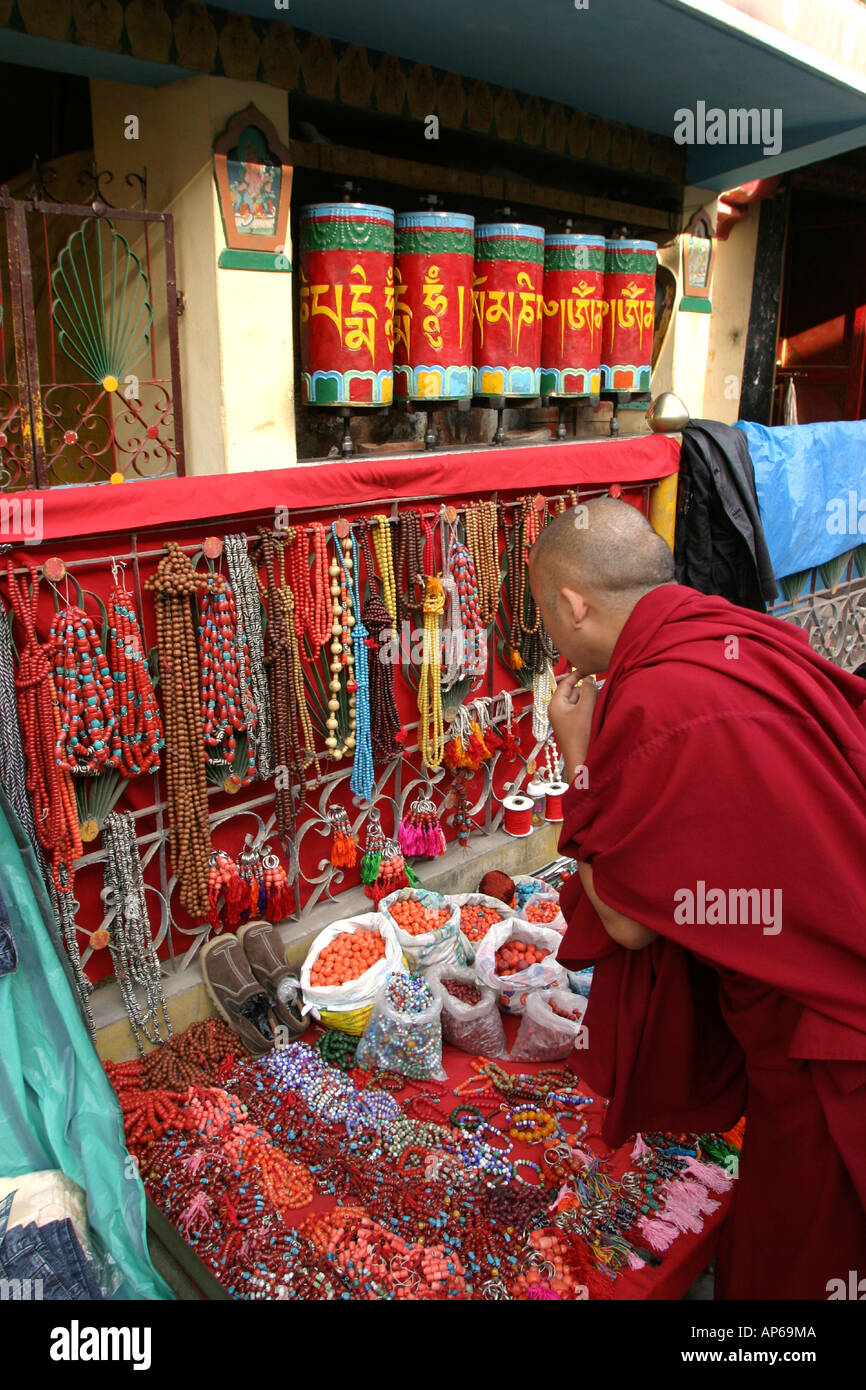 India Himachal Pradesh McLeod Ganj tibetano monaco buddista guardando stallo del tallone dal tempio ruote della preghiera Foto Stock