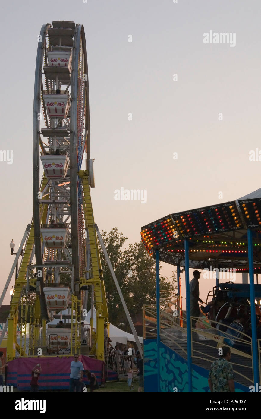 Qui ci sono 2 tipi diversi di Amusement Park rides: il tradizionale, easy-going ruota panoramica Ferris & 'spin till you drop' tipo. Foto Stock