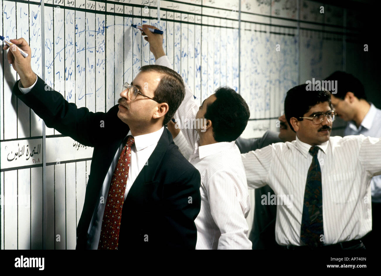 I commercianti la pubblicazione di prezzi di magazzino sul pre 2001 manuale prezzo di stock di schede sul mercato finanziario di Amman trading floor in Giordania Foto Stock