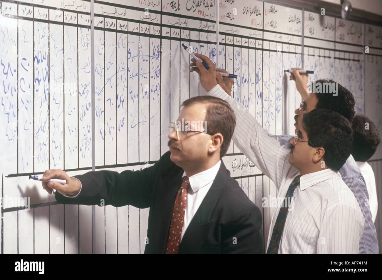 I commercianti la pubblicazione di prezzi di magazzino sul pre 2001 manuale prezzo di stock di schede sul mercato finanziario di Amman trading floor in Giordania Foto Stock