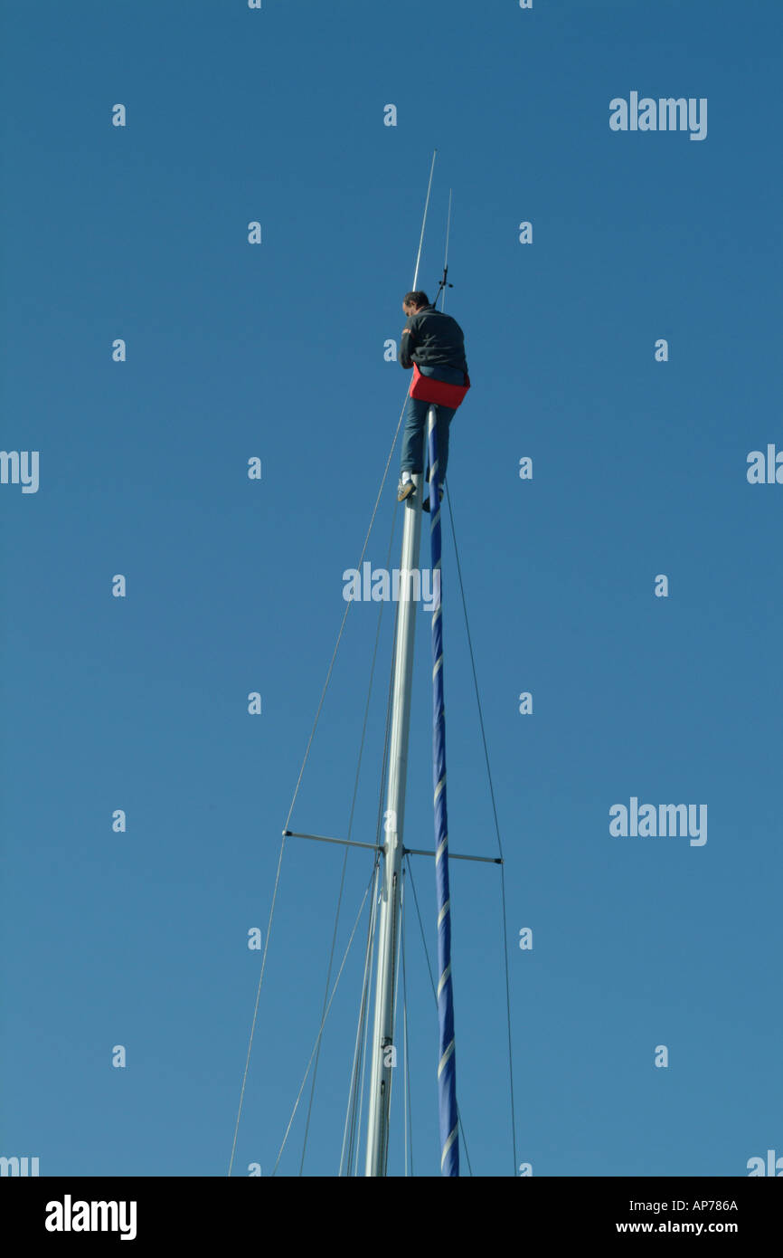 Crewman sulla cima di un palo di Cherbourg Harbour Marina Foto Stock