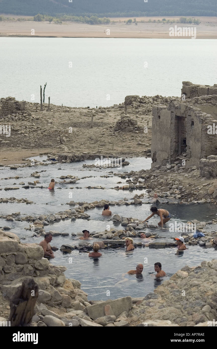 Persone si bagnano in corrispondenza di una sorgente termale che è stata sommersa dalle acque di Yesa serbatoio per un tempo più lungo di quanto più possibile ricordare Foto Stock