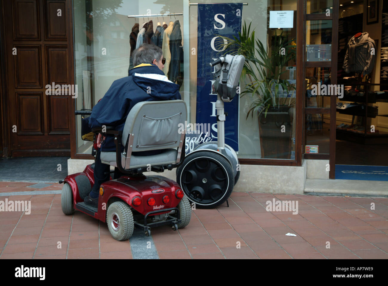 Uomo disabili in carrozzella ammirando segway scooter Foto stock - Alamy