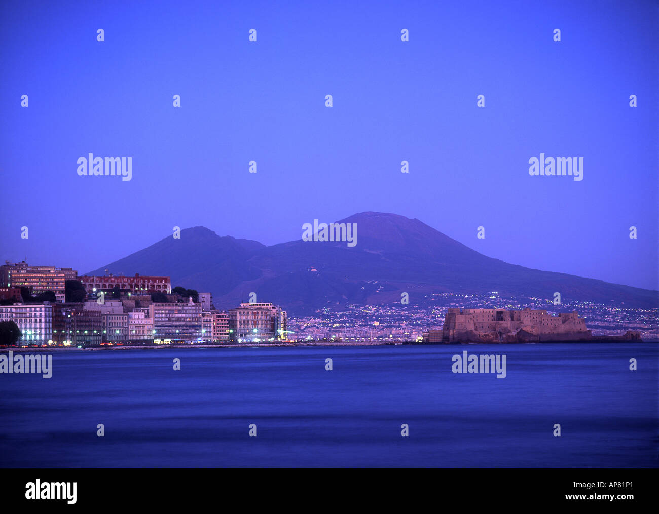 Castel dell' Ovo e Napoli al crepuscolo della notte il Vesuvio sullo sfondo Campania Italia Foto Stock