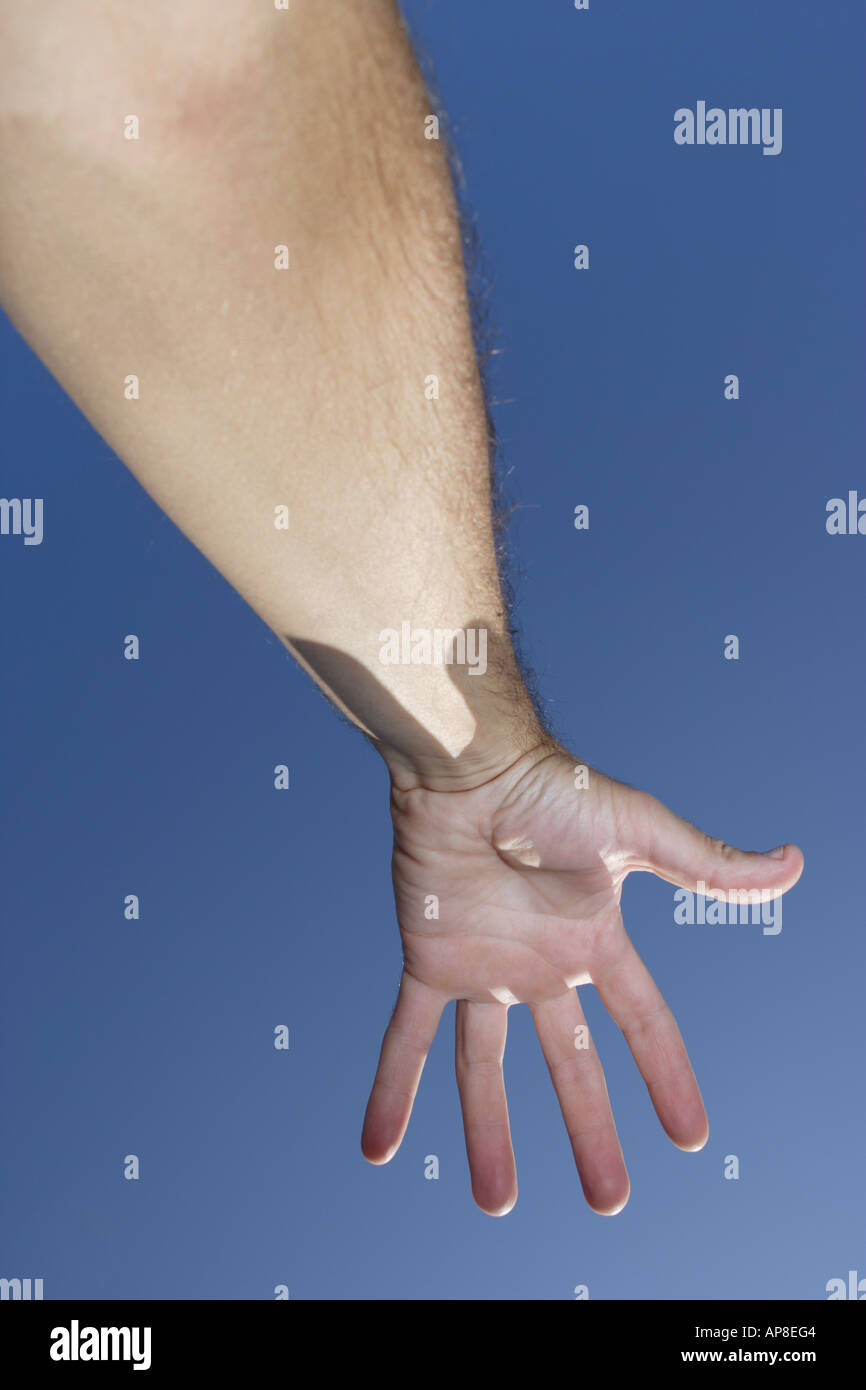 La mano in aria cielo blu dietro Foto Stock