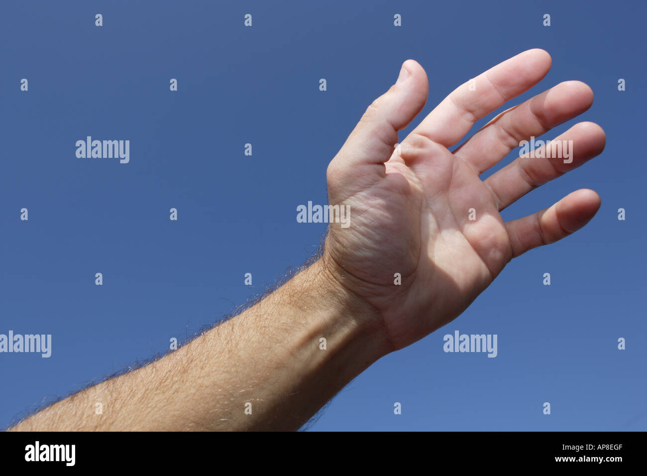 La mano in aria cielo blu dietro Foto Stock