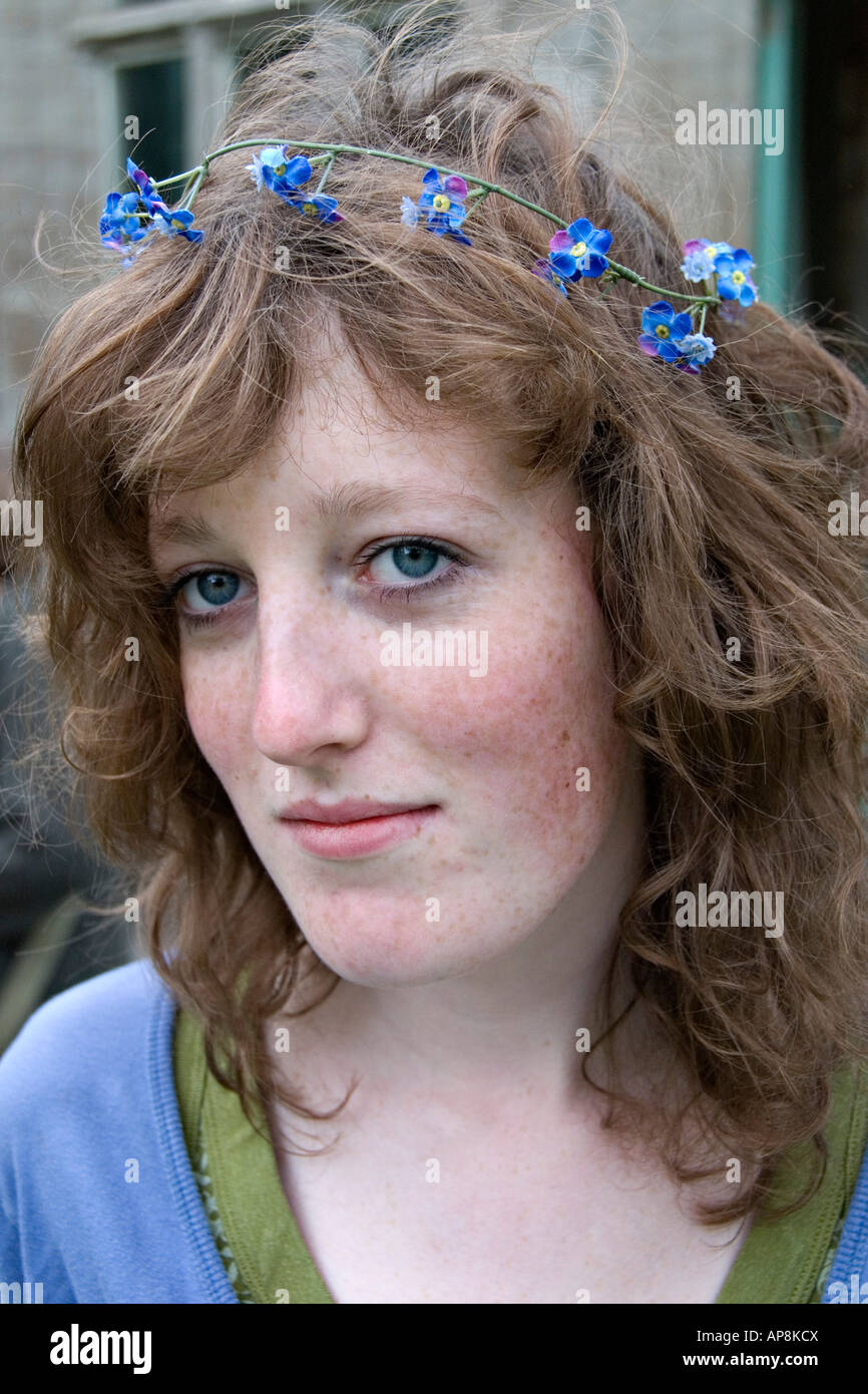 Blue-eyed teenage ragazza inglese con una ghirlanda di fiori blu nel suo  marrone capelli Foto stock - Alamy