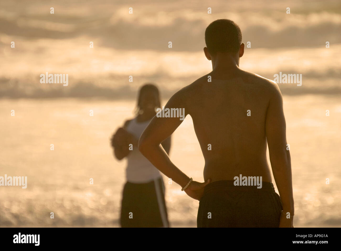 Due giovani uomini che giocano a calcio in spiaggia. Foto Stock