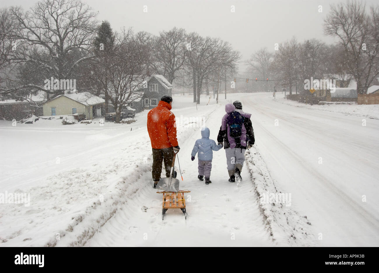 Famiglia camminare insieme sulle strade innevate carreggiata Foto Stock