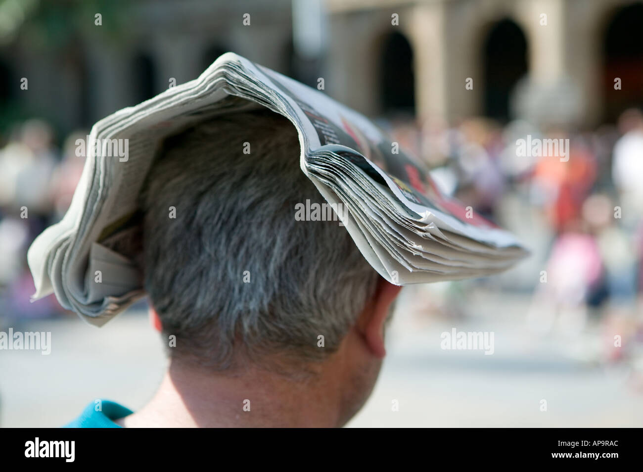 Uomo con un giornale ripiegato bilanciato sulla sua testa per lo proteggono dal sole Bilbao Spagna Foto Stock