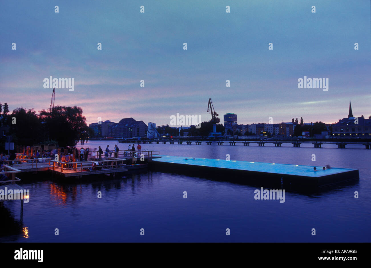 Berlino. Badeschiff an der Arena am Abend. Badeschiff in serata. La gente di nuoto, rilassarsi e godersi il tramonto e lo skyline. Foto Stock