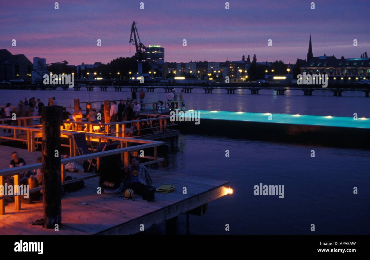 Berlino. Badeschiff an der Arena am Abend. Badeschiff in serata. La gente di nuoto, rilassarsi e godersi il tramonto e lo skyline. Foto Stock