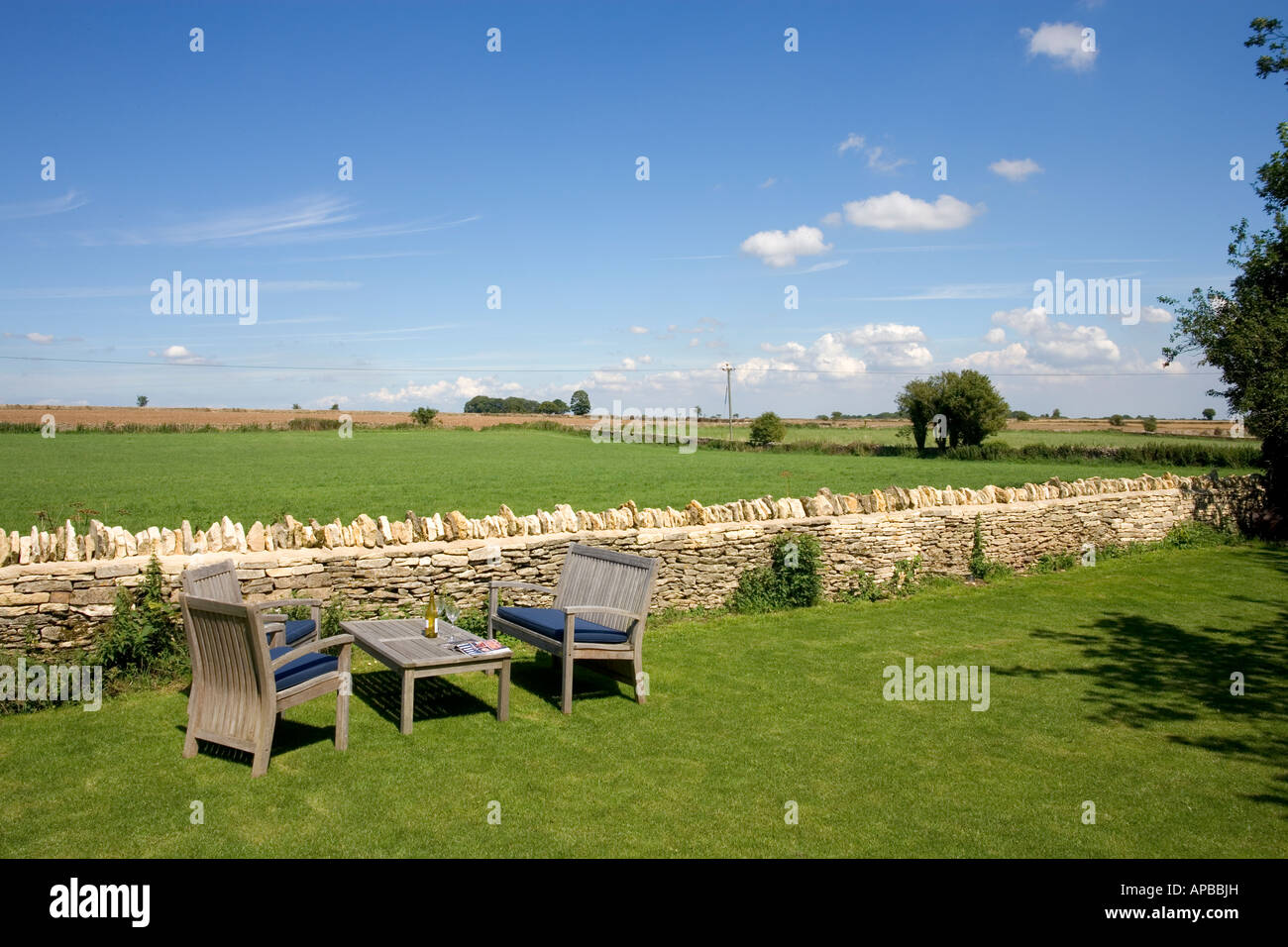 Giardini del Regno Unito. Tavolo e sedie da giardino e una vista sulla campagna aperta. Foto Stock