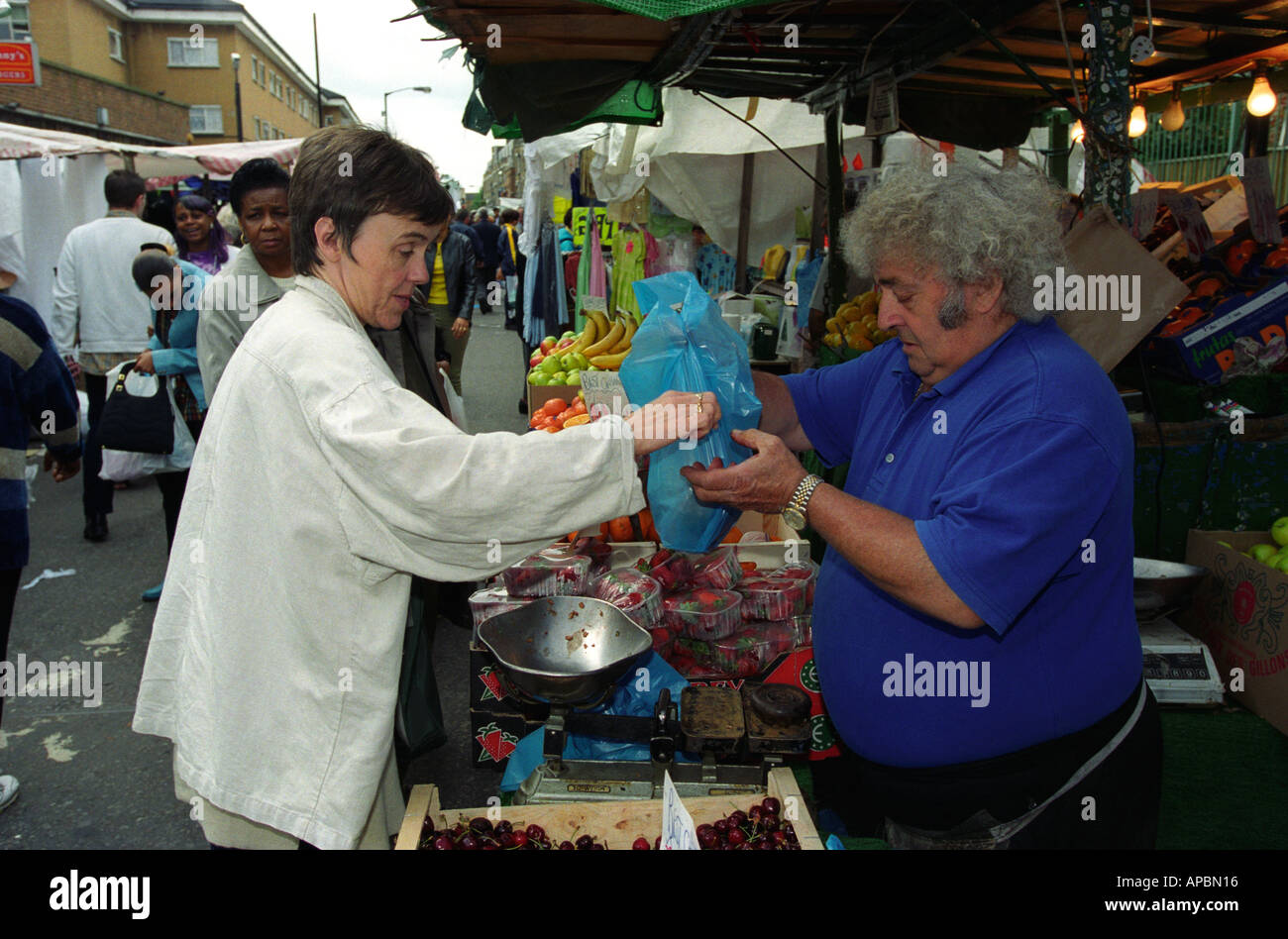 Donna acquistare frutta e verdura al mercato, di stallo Peckham, Southwark, Londra, Regno Unito. Foto Stock