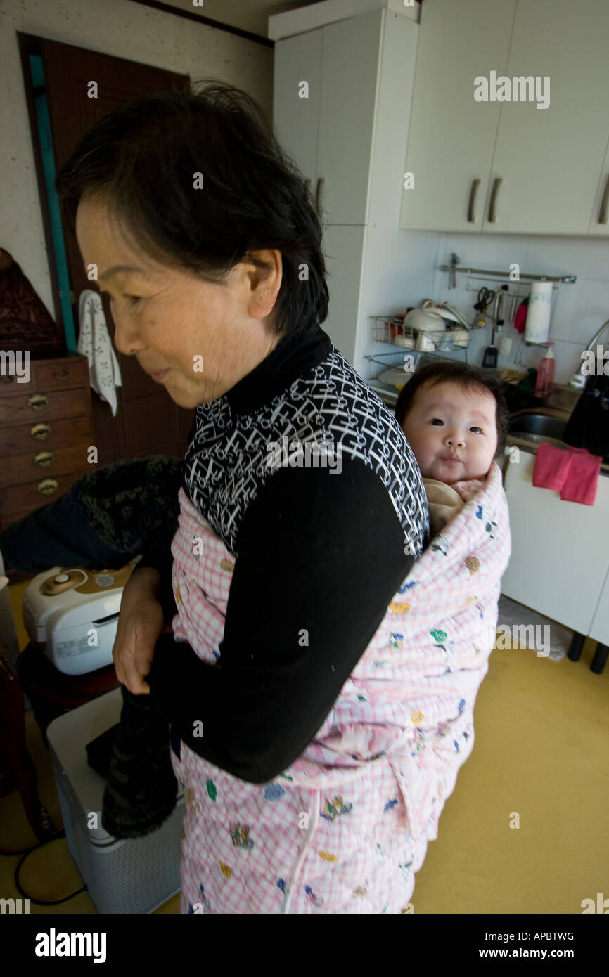 Il coreano nonna con giovani Baby Strapped per il suo ritorno in stile tradizionale Seoul COREA DEL SUD Foto Stock