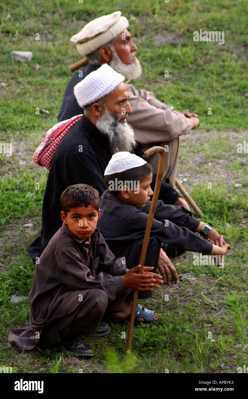 Gli uomini anziani e giovani ragazzi osservando una distribuzione di elementi di rilievo per le vittime del terremoto in Kaful Ghar vicino Bagh, AJK Kashmir Foto Stock