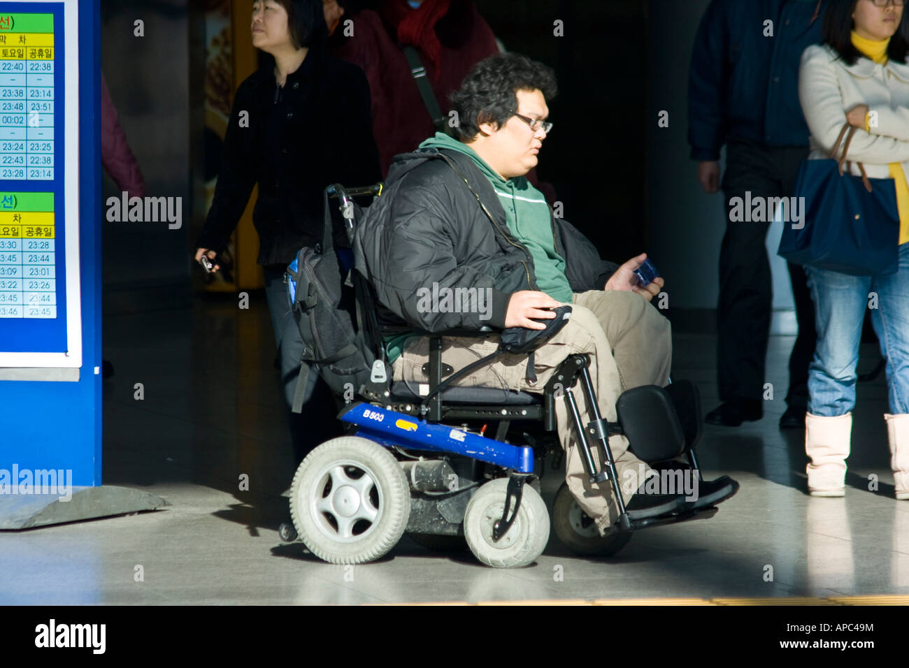 Portatori di handicap giovane uomo in una sedia elettrica Seoul COREA DEL SUD Foto Stock