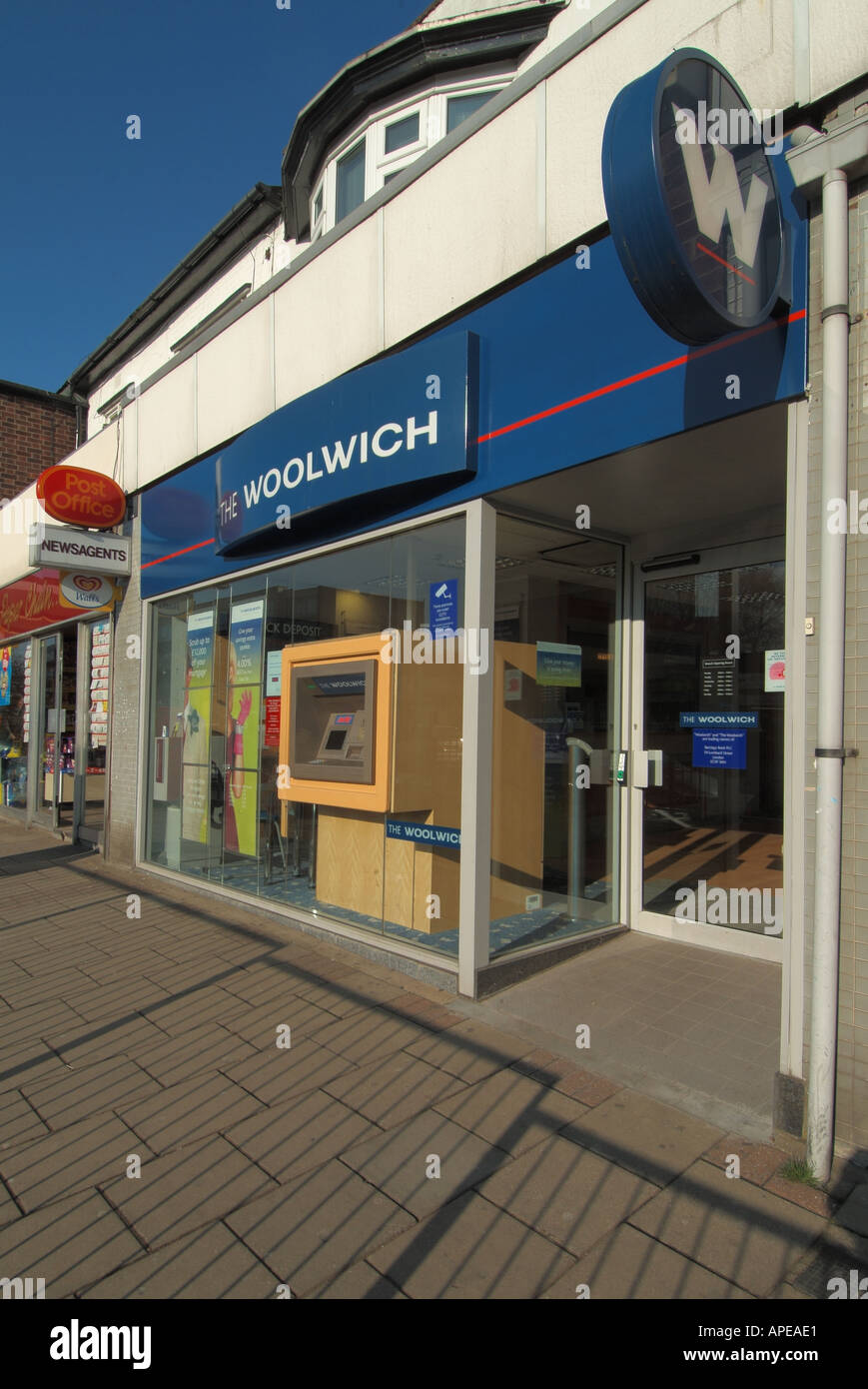 Locali filiali della banca Woolwich con operazioni automatizzate di cash  dispenser adiacente a Post Office Foto stock - Alamy