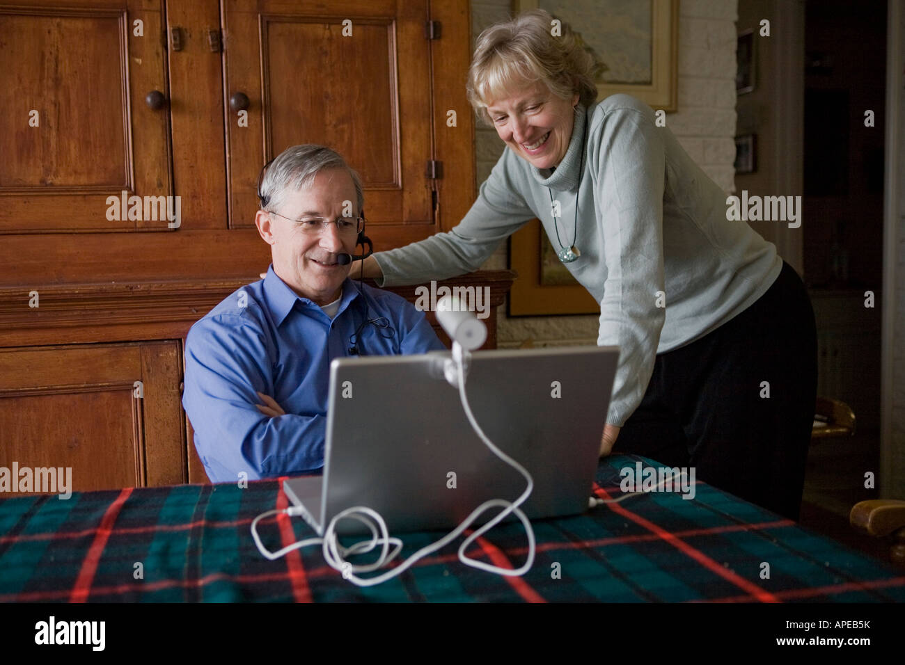 Un uomo parla al telefono su un computer. Foto Stock