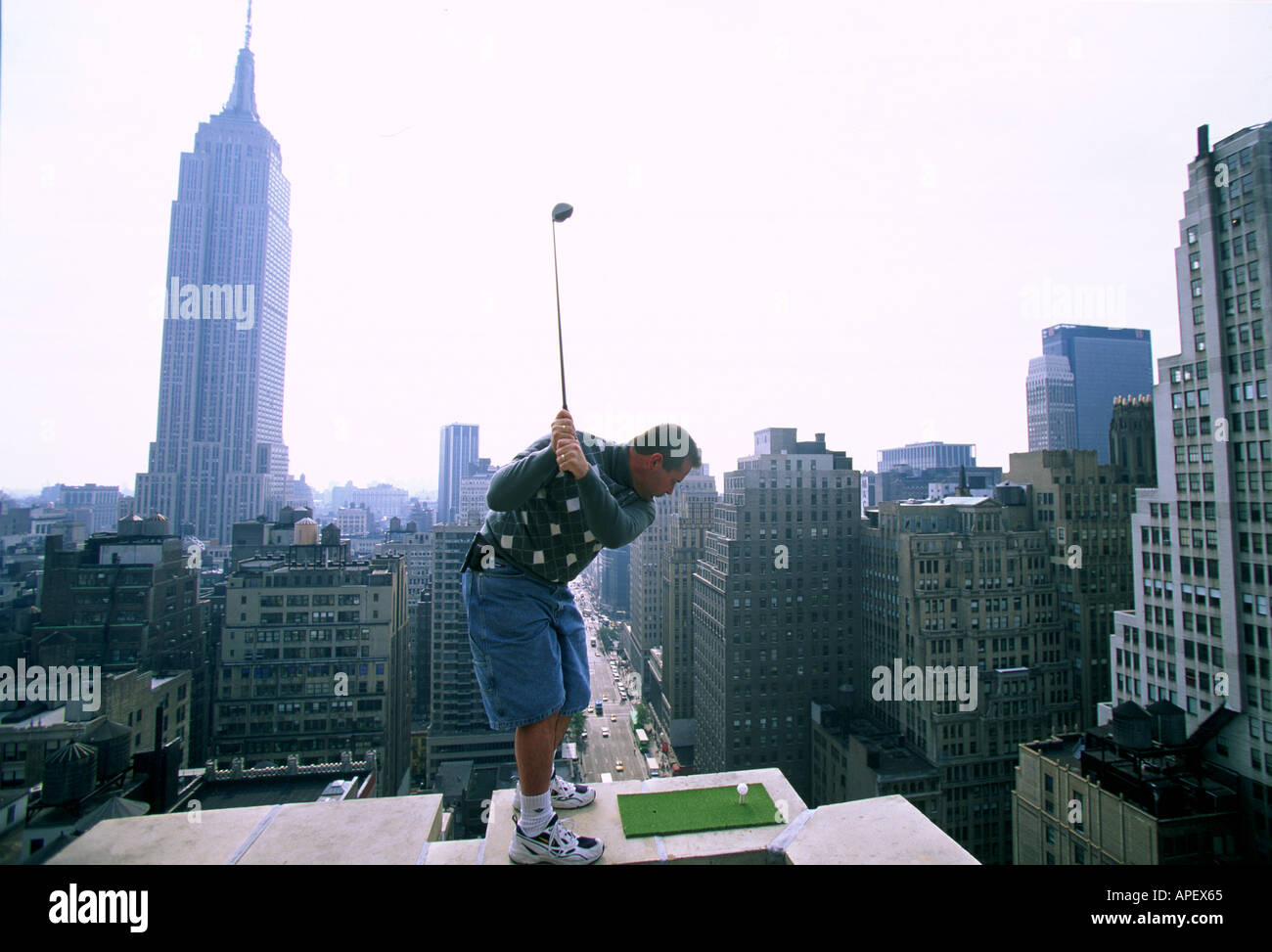 Il Golfer sulla sommità del grattacielo con sottostante città, Empire State building Foto Stock